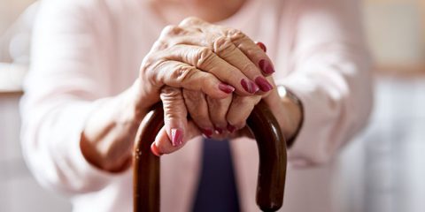 Pflege zu Hause – ältere Frau hält einen Gehstock