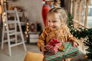 Kleines Mädchen mit Weihnachtsgeschenken