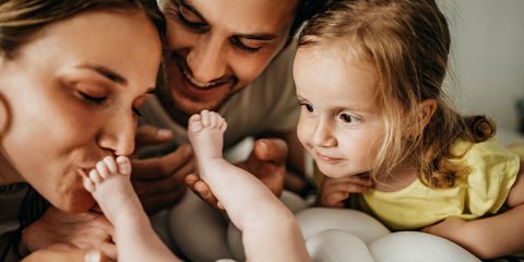 Mutter küsst Fuß von ihrem Baby – Elternzeit