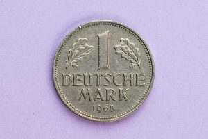 Deutsche Mark Münze auf lilafarbenen Hintergrund