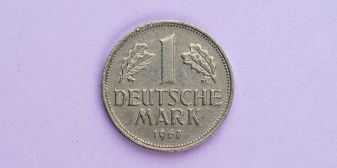 Deutsche Mark Münze auf lilafarbenen Hintergrund