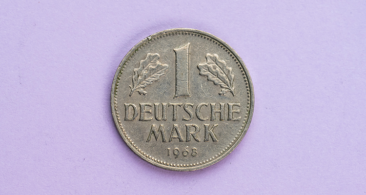 Deutsche Mark Münze auf lilafarbenen Hintergrund